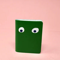 Green leather notebook with googly eyes