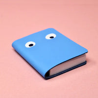 Blue leather notebook with googly eyes