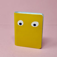 Yellow leather notebook with googly eyes