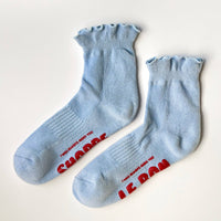 Pair of periwinkle socks with ruffles andred text