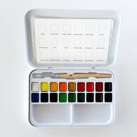 Watercolor paint set with color swatches and a brush