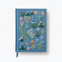 Blue notebook with floral embroidery on a white background