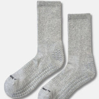 A pair of light gray ribbed knit socks with textured grip patterns on the soles, displayed against a clean off-white background.