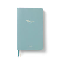 Light blue PU leather notebook with 'work in progress' text