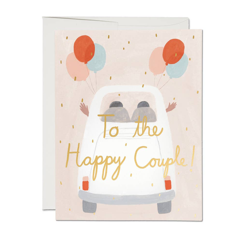 wedding card that says to the happy couple. the couple is in a car