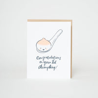 Greeting card featuring a spoon with a smal dumpling and text 'Congratulations on your lil' dimpling' 