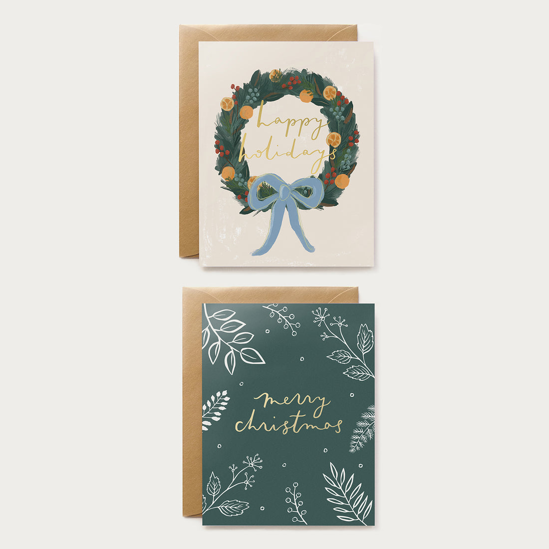 two christmas greeting cards in a box set with a wreath and foliage