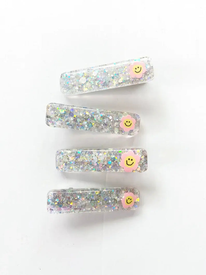 glitter hair clips in the color of  silver with a smiling flower