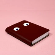 Brown leather notebook with googly eyes