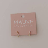 pair of gold huggie hoop earrings with oval cut cubic zirconia 