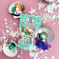 Mermaid-themed playset with packaging on a pink background