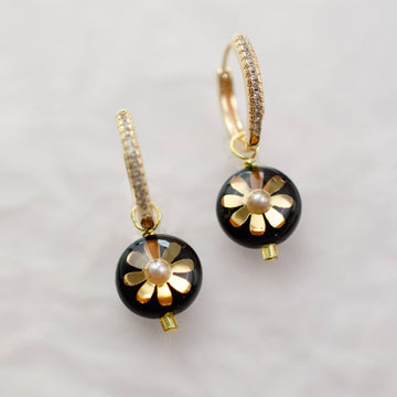 onyx black beaded dangle earrings with a gold flower 