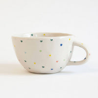 Ceramic mug with colorful speckles on a white background