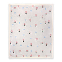 A baby blanket with a white border and a delicate floral pattern featuring pink and blue flowers 