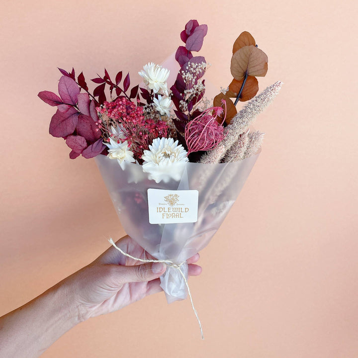 A petite dried bouquet of flowers in fall colors 