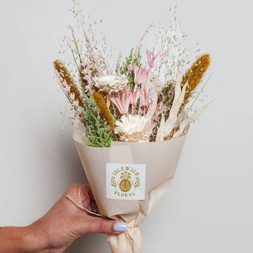 A petite dried bouquet of flowers in warm tones 