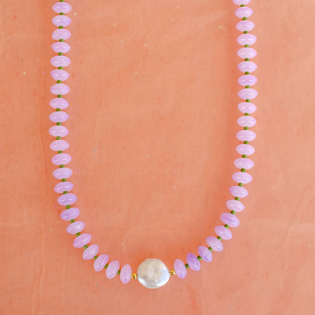 purple beaded necklace with a mother of pearl 