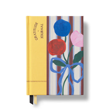 Gratitude journal with floral design on a striped background