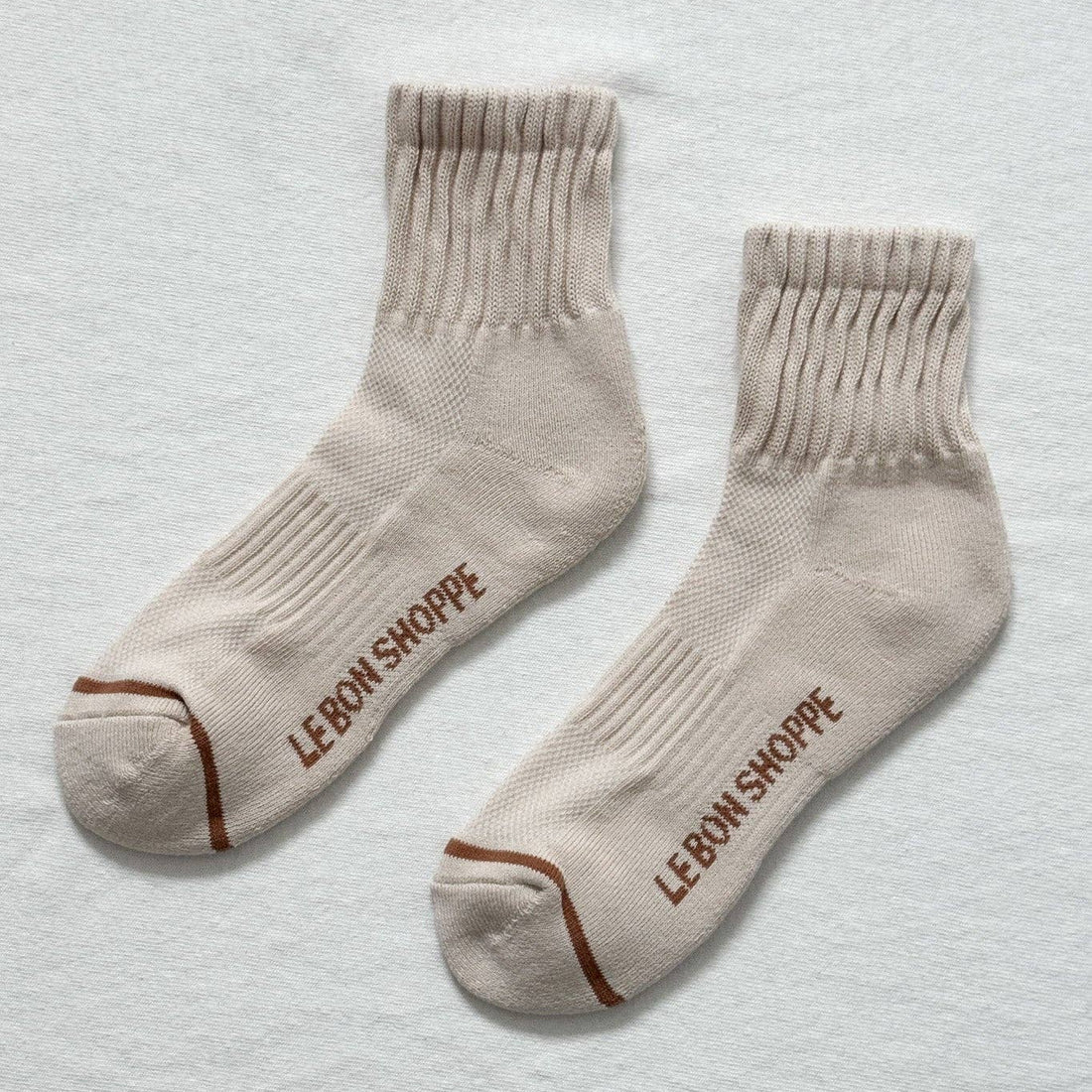 beige socks with a brown stripe on the toe box