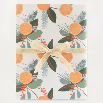 festive holiday gift wrap roll with citrus fruit and pine and hollies 
