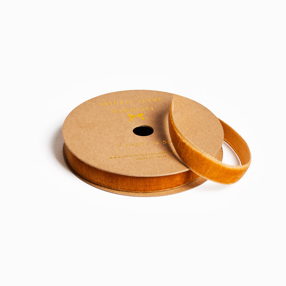 Wooden spool with orange ribbon on a white background