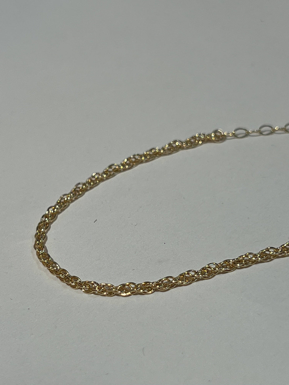 Gold chain on a light gray background