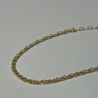 Gold chain on a light gray background