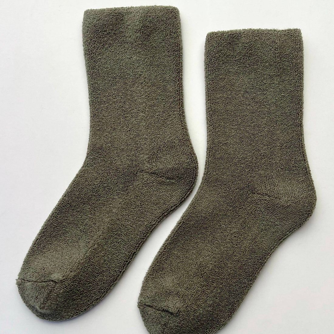 A pair of dark olive green crew socks laid flat on a plain white background.