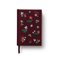 Maroon notebook with floral embroidery on a white background
