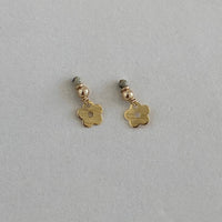 Gold flower-shaped earrings on a light gray background