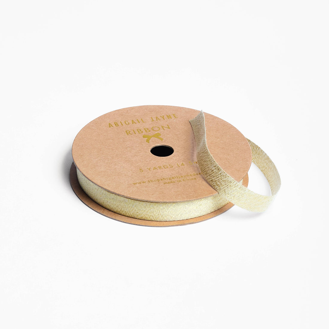 Spool of gold ribbon on a white background