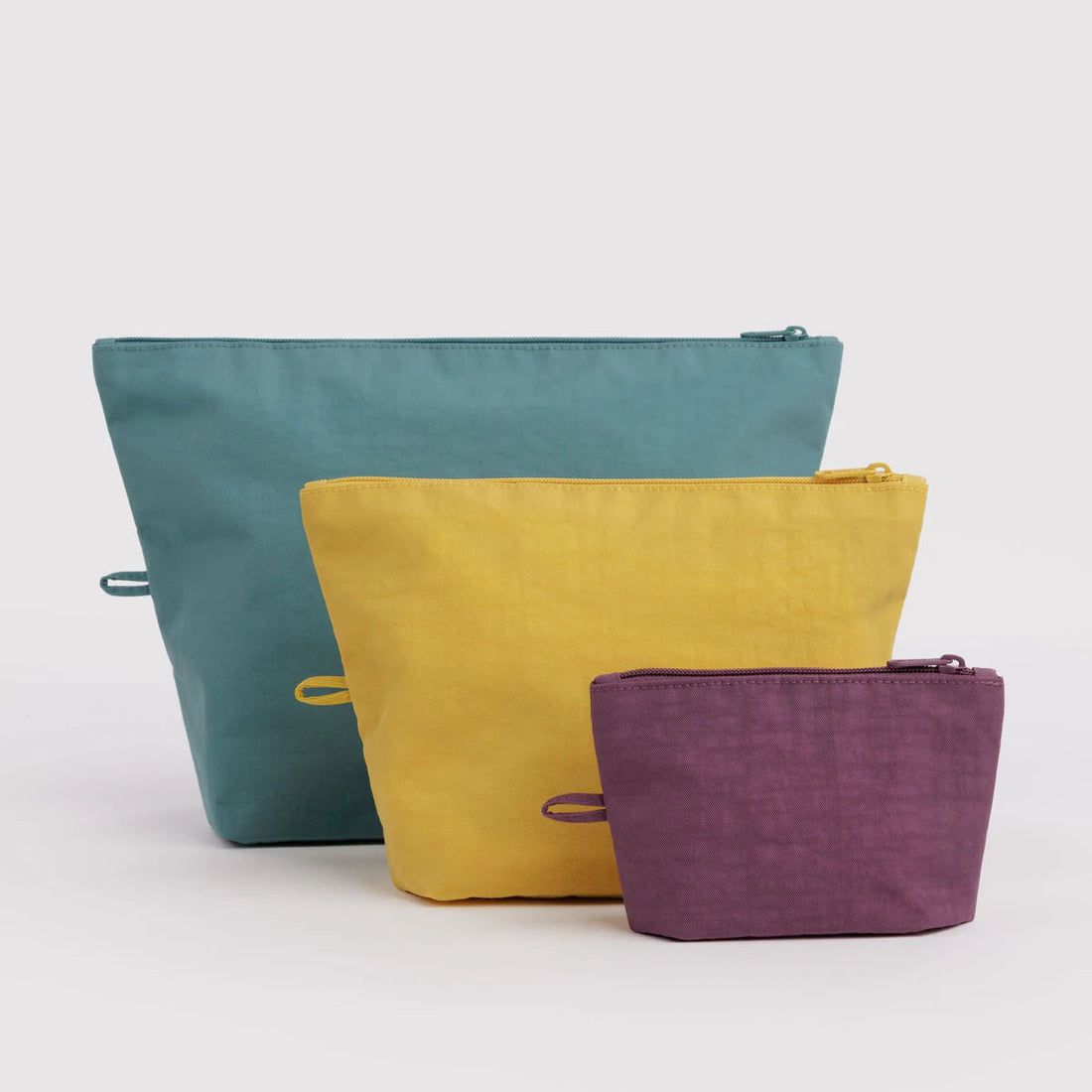 teal, mustard yellow, and plum travel pouches varying sizes
