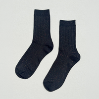 A pair of dark navy ribbed crew socks with subtle multicolor flecks, displayed flat against a light off-white textured background.