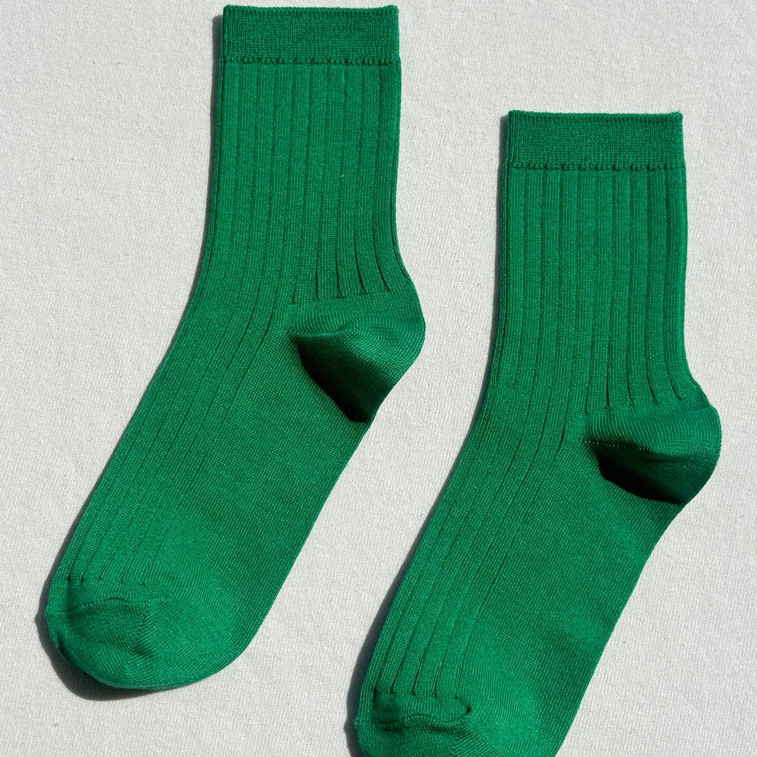Pair of green socks on a light gray background