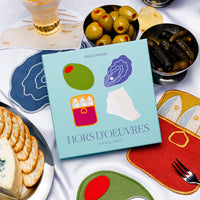 Hors d'oeuvres cocktail napkins with crackers, olives, oysters, sardines, and pickles