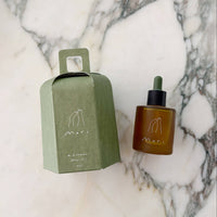 Brown bottle with dropper and green box on a marble surface