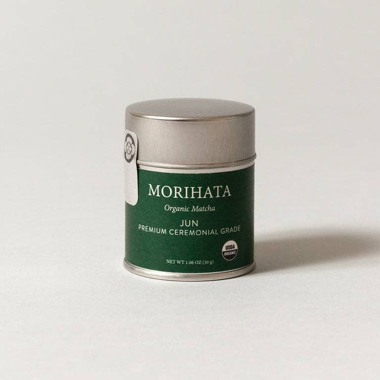 A small cylindrical metal tin of Morihata Organic Matthu Jun Premium Ceremonial Grade tea, featuring a dark green label and a brushed silver lid, set against a plain light gray background.