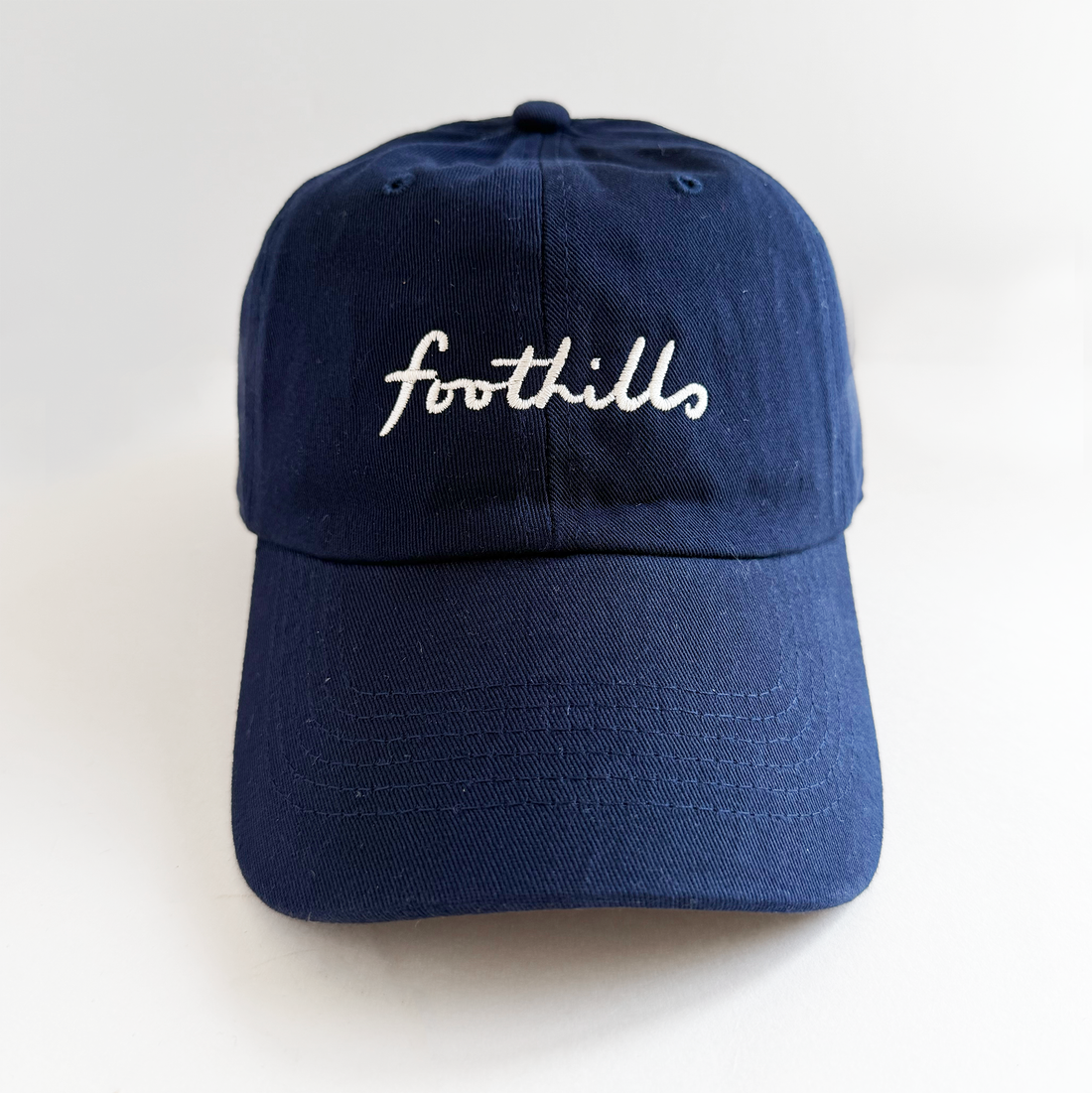navy baseball hat with foothills lettering in white embroidery 