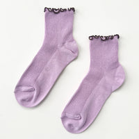 Pair of purple socks with brown trim on a white background