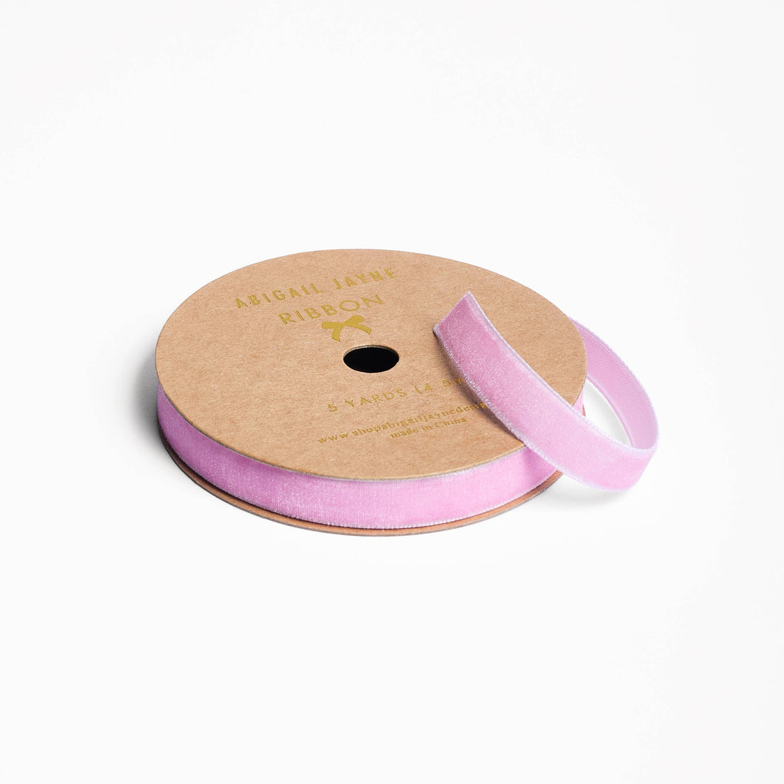 Spool of pink ribbon on a white background
