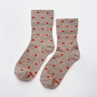 A pair of heather taupe crew socks with a pattern of small red hearts and red text near the toes, displayed on a clean white background.