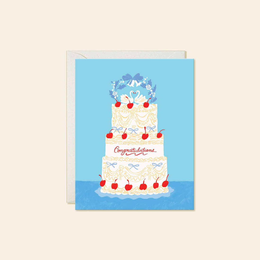 A greeting card with a white envelope behind it, featuring an illustration of a decorated three-tier wedding cake with cherries and the word 'Congratulations' 